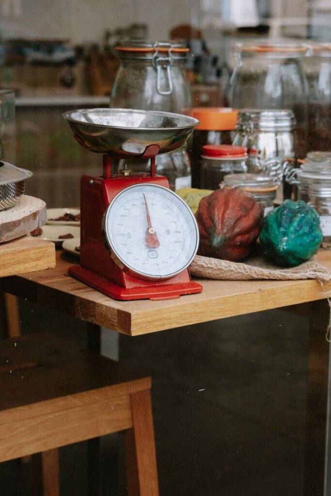 Analoge keukenweegschaal retro: rode vintage weegschaal met metalen schaal in een keuken