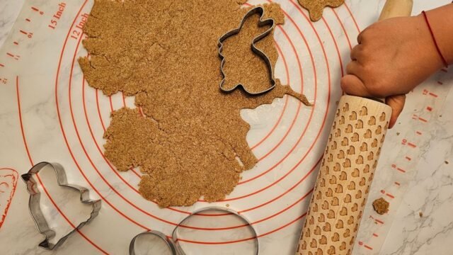 Bakmat met maataanduiding: kind rolt koekjesdeeg uit op een siliconen mat met maatcirkels