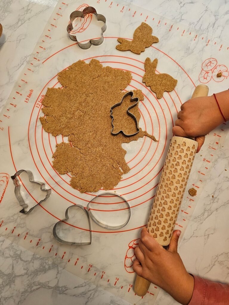 Bakmat met maataanduiding: kind rolt koekjesdeeg uit op een siliconen mat met maatcirkels