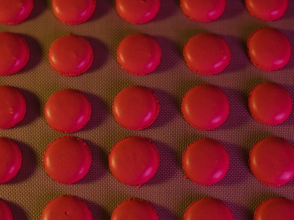 Bakmat siliconen: rode macaronschelpen op rijen op een bakmat