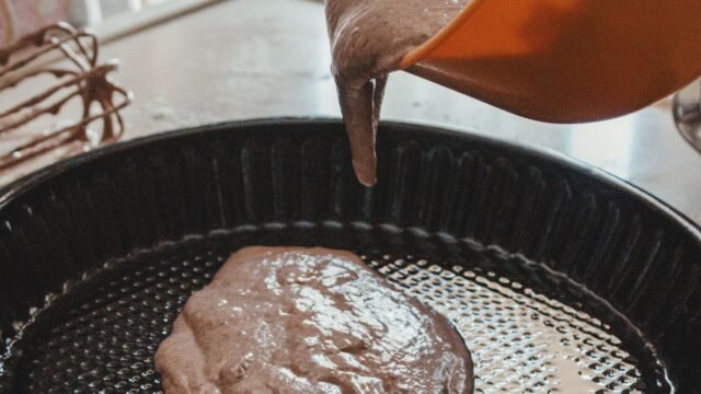 Bakvormen BPA vrij: chocoladebeslag wordt in een ronde metalen bakvorm gegoten