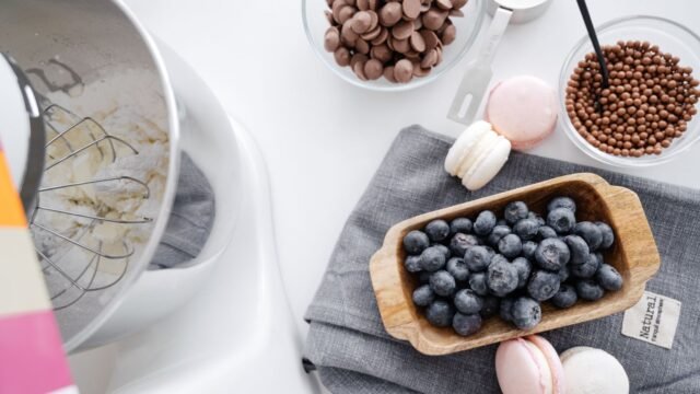 Goedkope keukenrobot kneden: keukenrobot met kom naast macarons en blauwe bessen