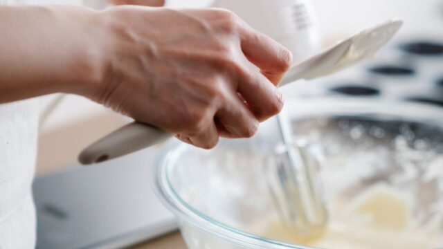 Handmixer met deeghaken: beslag mengen met een witte handmixer in een glazen kom