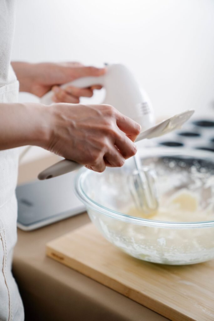Handmixer met deeghaken: beslag mengen met een witte handmixer in een glazen kom