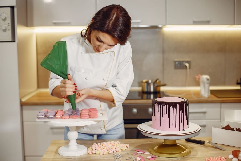 Herbruikbare spuitzak: banketbakster spuit crème met een groene spuitzak naast een drip cake