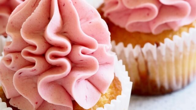 Kartelspuitmondje gekruld: cupcakes met gekrulde roze botercrème rozetten