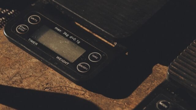 Keukenweegschaal 0.1 gram nauwkeurig: kleine digitale precisieweegschaal op een houten werkblad
