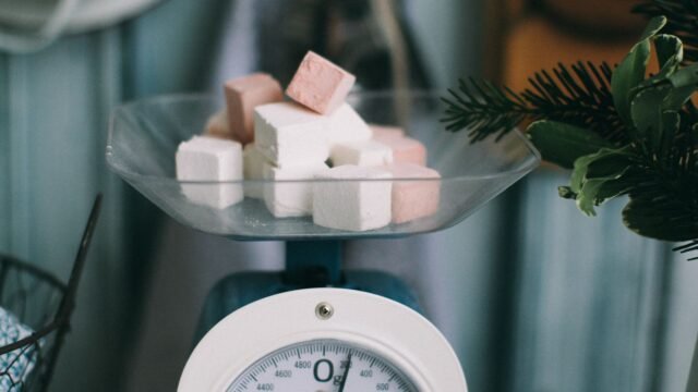 Mechanische keukenweegschaal ijken: vintage keukenweegschaal met suikerklontjes in de schaal