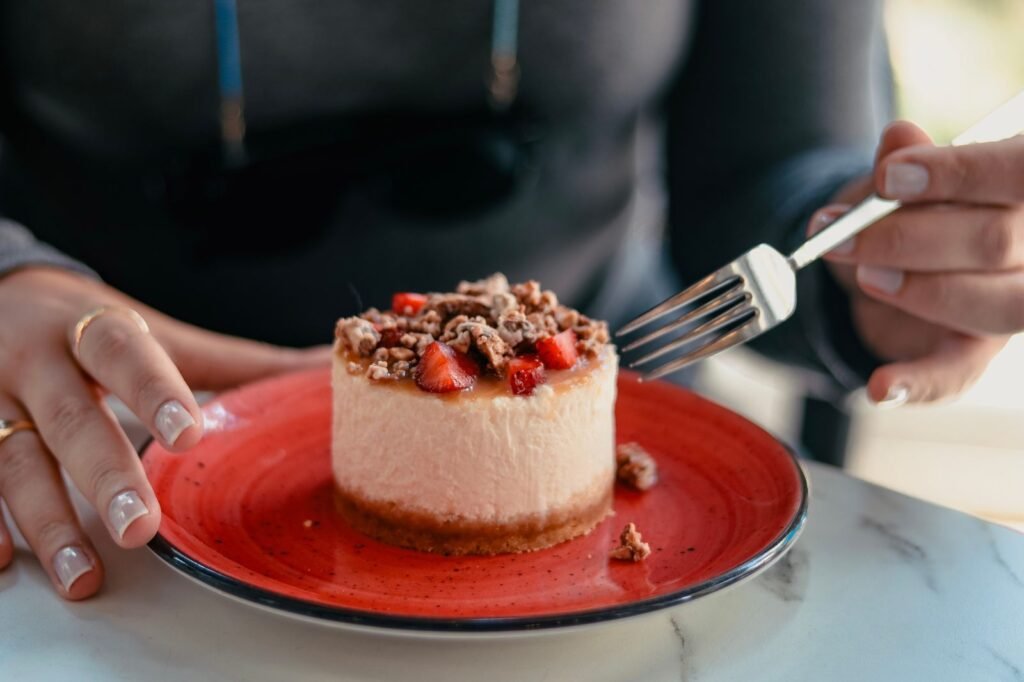 Mini springvormpjes set: individuele mini-cheesecake met aardbeien en noten op een rood bord