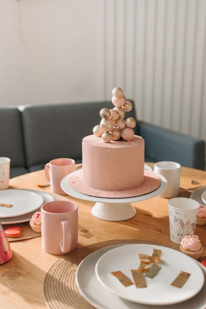 Taartplateau keramiek: roze verjaardagstaart op een wit keramisch taartplateau op een gedekte tafel