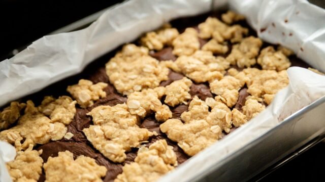 Vierkante springvorm: chocoladerepen met crumble in een vierkante bakvorm met bakpapier